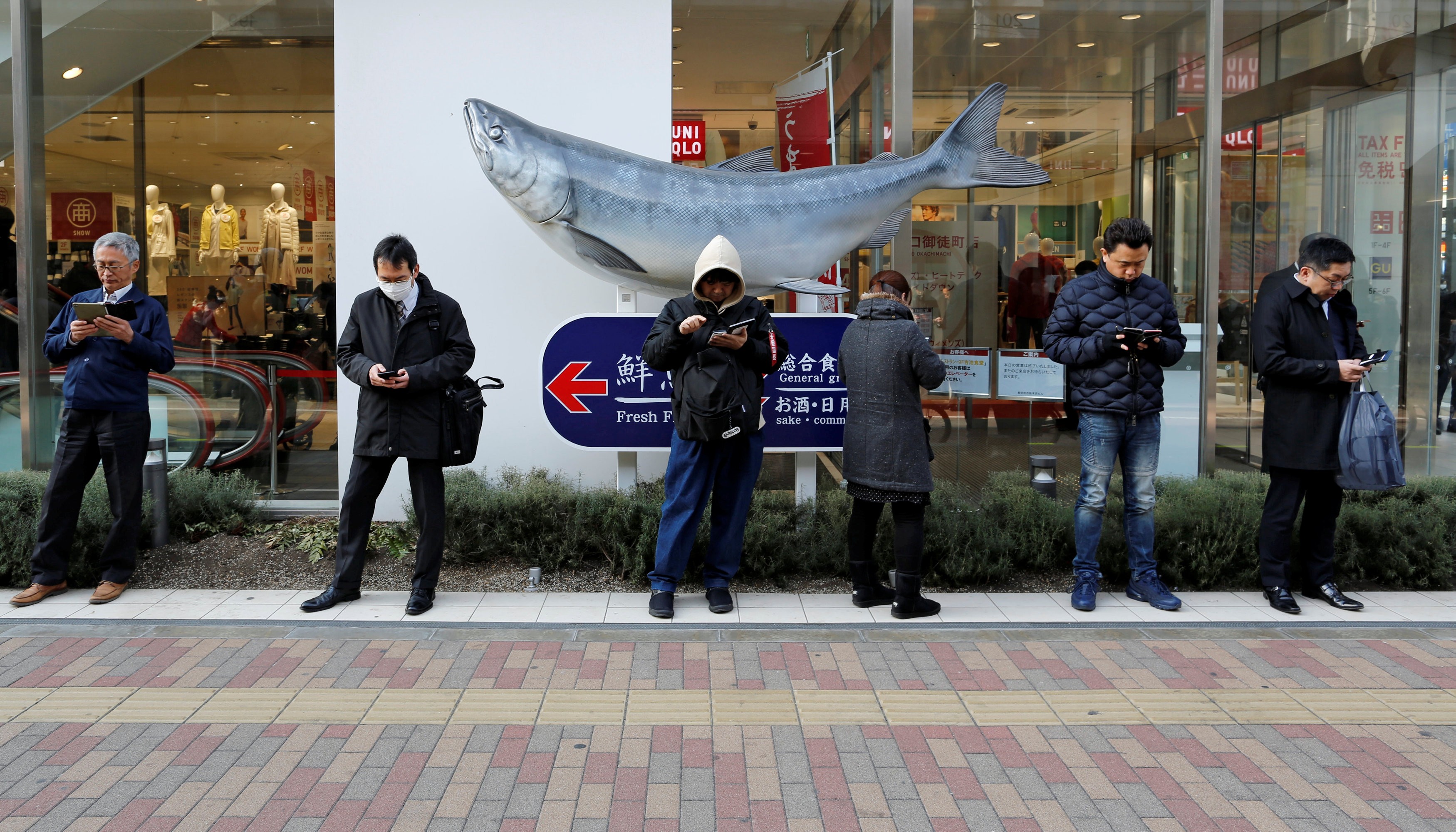 People use their smartphones on a street in Tokyo. Photo: Reuters