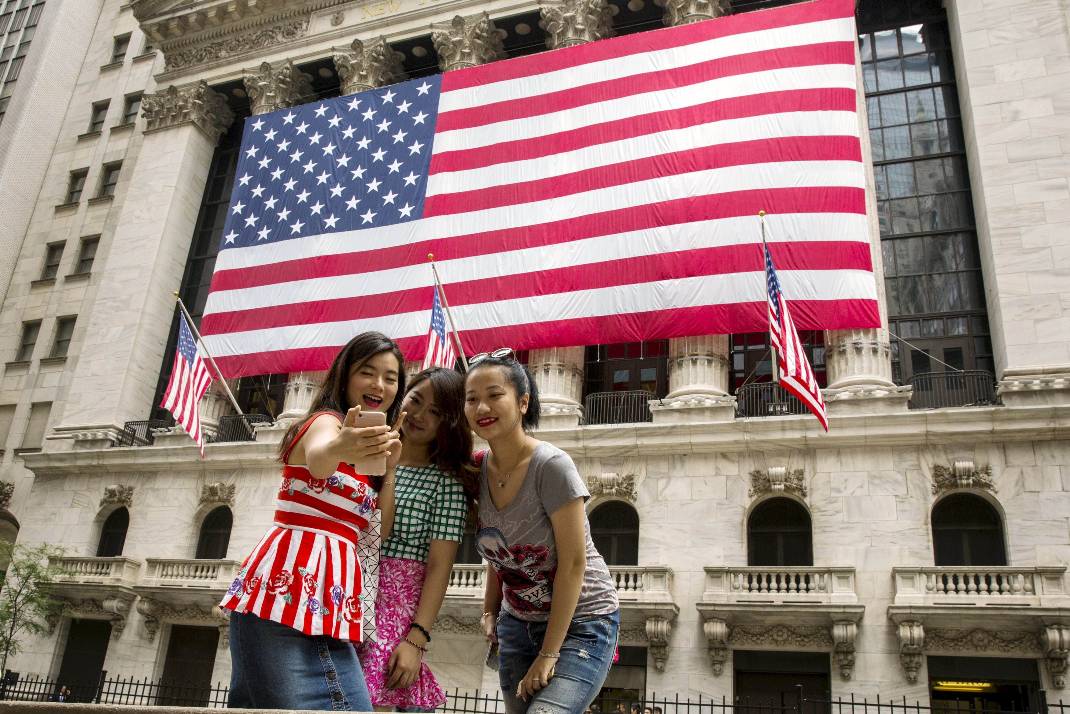 Chinese tourists take a selfie outside the New York Stock Exchange. Photo: Reuters