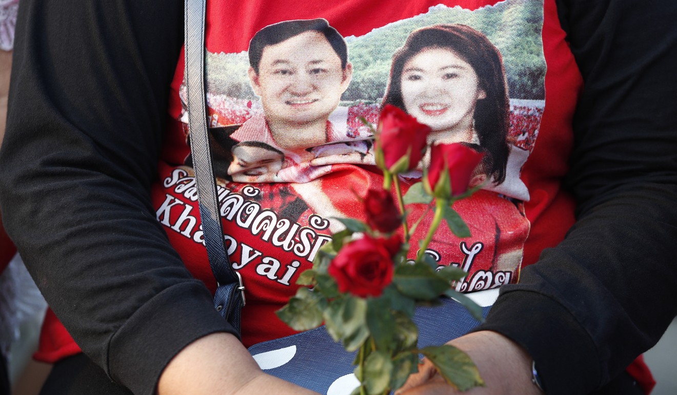 A supporter of the Shinawatras wear a T-shirt showing Thaksin and Yingluck. Photo: EPA