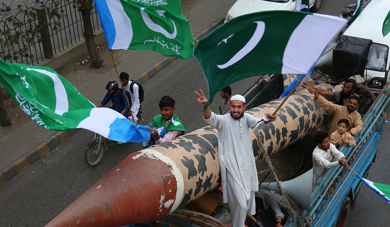 Pakistani protesters with a makeshift replica missile shout slogans in Karachi. Photo: EPA