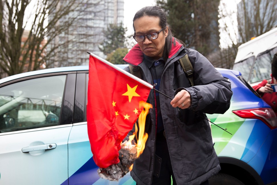 Yang Kuang burns a Chinese flag outside the court. Photo: AFP