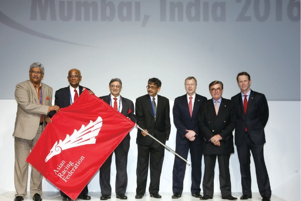 The ARF flag is passed from Hong Kong to India, which will become the host country for the 36th Asian Racing Conference. From right: Secretary-General of the ARF Andrew Harding; HKJC Chairman T. Brian Stevenson; New ARF Chairman and HKJC CEO Winfried Engelbrecht-Bresges; and Chairman of the Turf Authority of India Vivek Jain.