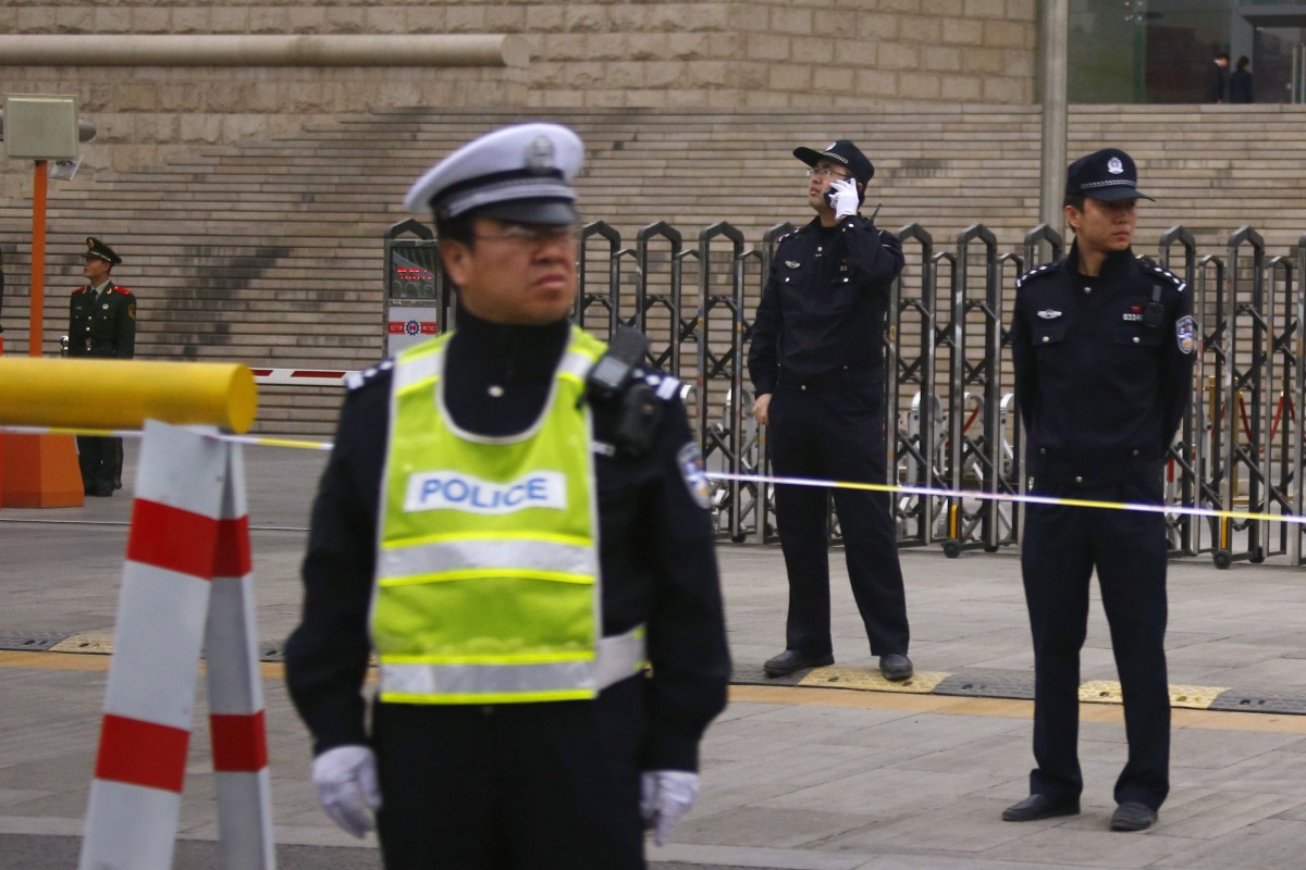 Police officers stand guard outside an entrance to Beijing Municipal High People's Court. Photo: Reuters
