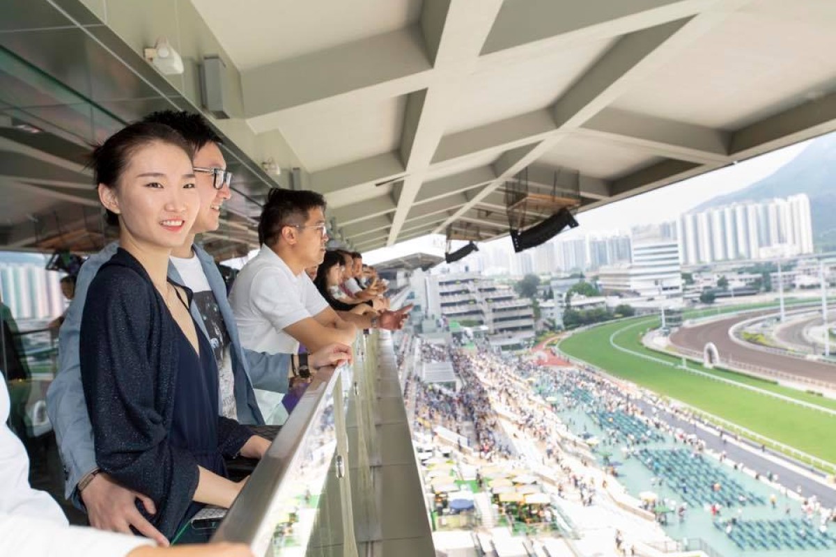 Privilege Club members watch the races from the balcony of the private member box at the Hong Kong Jockey Club Sha Tin Racecourse.