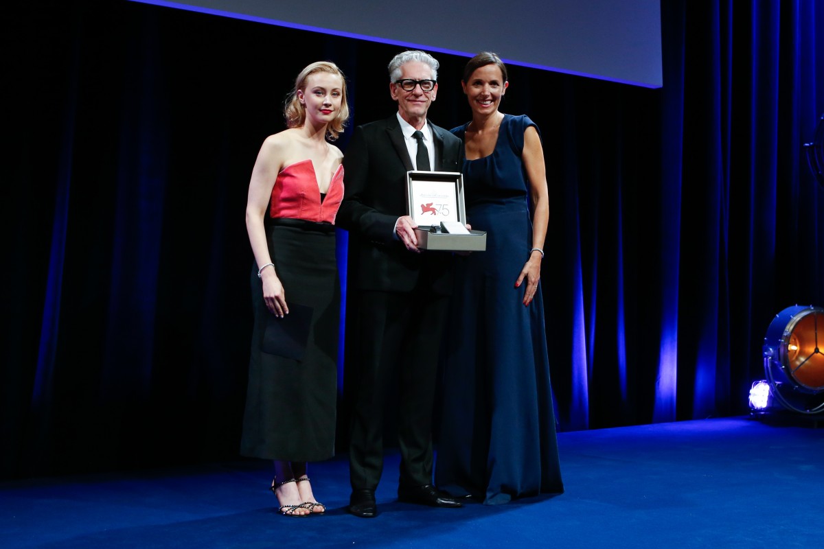 Sarah Gadon (left) and Catherine Rénier (right) present David Cronenberg (centre) with a personalised Reverso Leone d’Oro alla carriera watch.