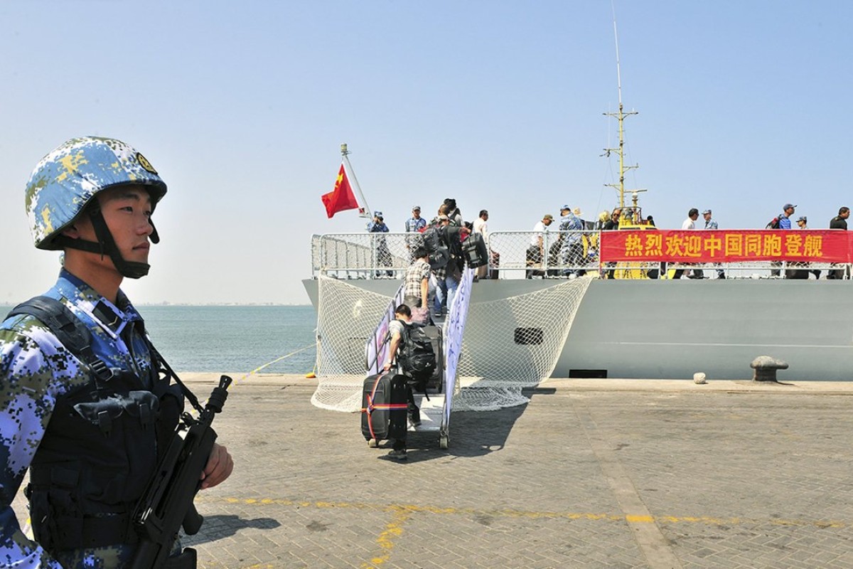 A People’s Liberation Army Navy soldier stands guard as Chinese citizens board a Chinese naval ship at a port in Aden last year. Photo: Reuters