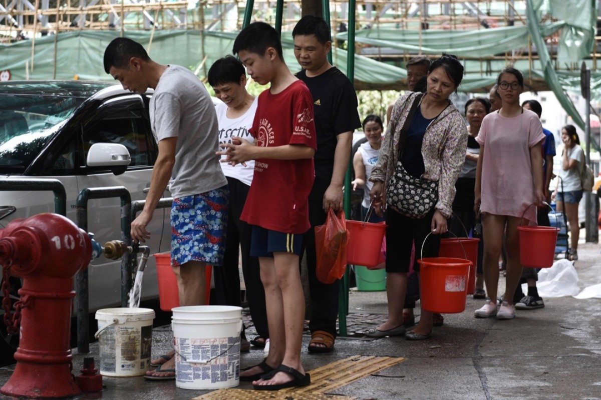 Residents queue up to collect water from a fire hydrant. Photo: AFP