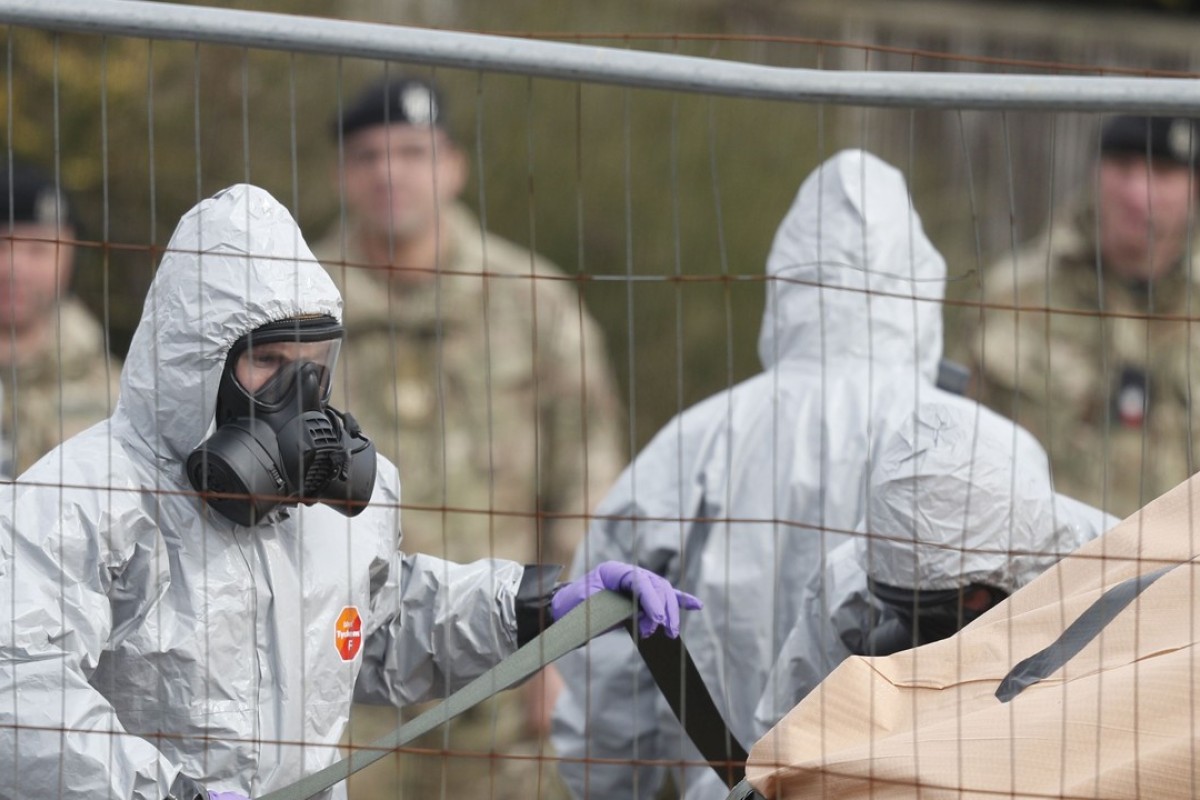 British military personnel wearing protective suits work on March 14  to remove a vehicle connected to the March 4 nerve agent attack in Salisbury, southeast England. Photo: AFP 