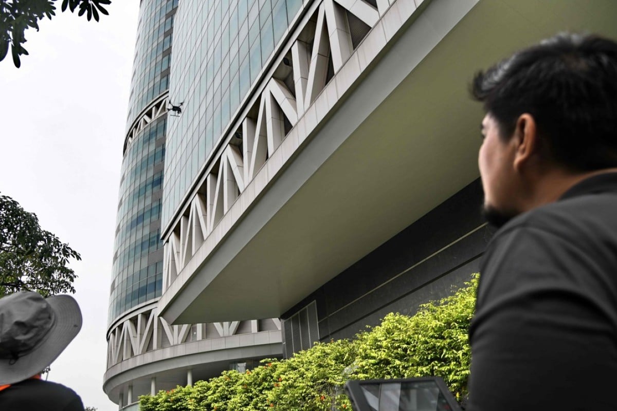 A staff member of Singapore technology firm H3 Dynamics using a drone to inspect a building facade in Singapore. Image: Roslan Rahman/AFP