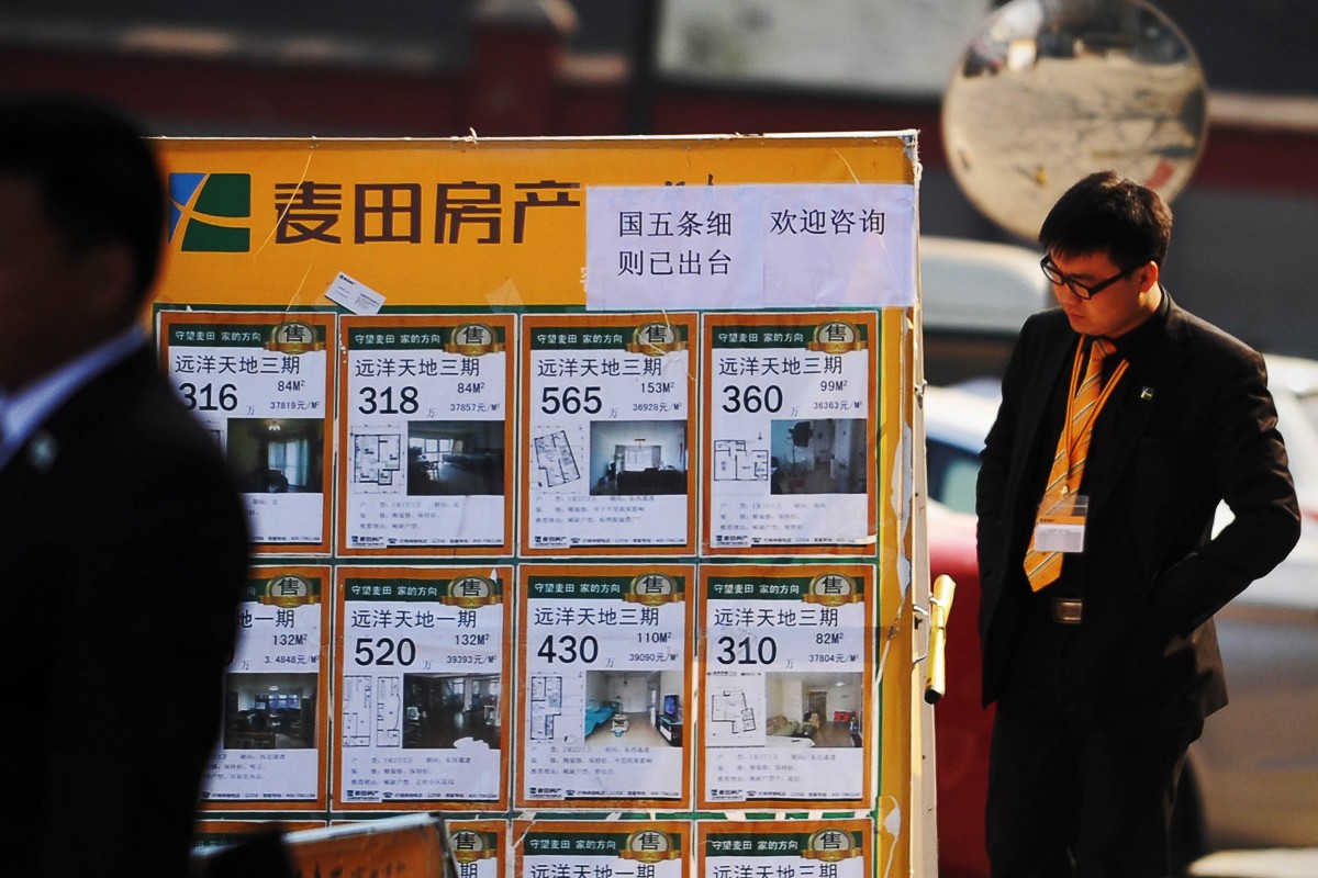 A real property agent checks a property advertising board in Beijing. According to a report by the Chinese government, property brokerages are among the country’s least scrupulous group of firms. Photo: Agence France-Presse