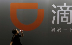 A woman walks past Didi Chuxing's stall at the Global Mobile Internet Conference 2017 in Beijing on Friday. Photo: Reuters