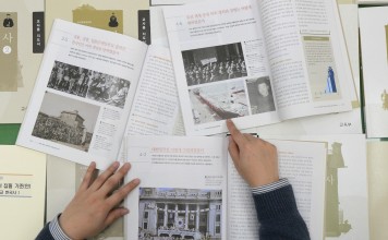 A government worker shows the final version of state-authored history textbooks President Moon is scrapping. Photo: AP