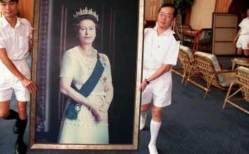 Two sailors carrying a portrait of Queen Elizabeth through the HMS Tamar ahead of the end of British rule in Hong Kong. Photo: AFP