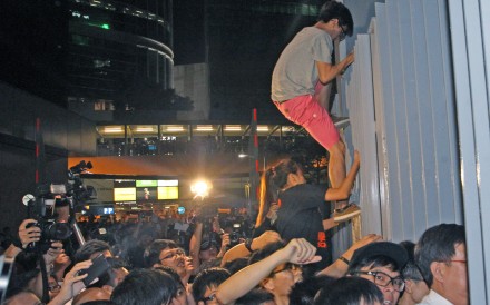 Some young protesters scale a fence as they try to break into the “Civic Square” forecourt of the government headquarters, in Admiralty on September 26, 2014. Photo: SCMP Pictures