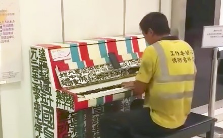 The mystery man in construction worker garb plays a piano in Sheung Tak Plaza in Tseung Kwan O. Photo: Facebook