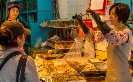 A seafood vendor weighs shrimp at a market in Hong Kong.