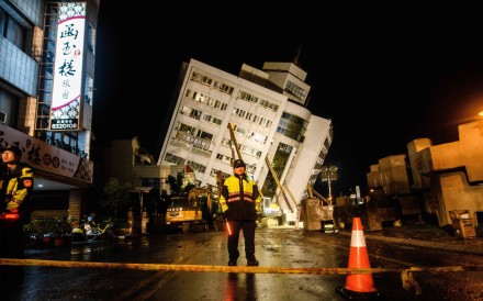 Rescuers at a cordon in front of the Yun Tsui building, which leaned to one side after an earthquake in Hualien, Taiwan. Photo: AFP