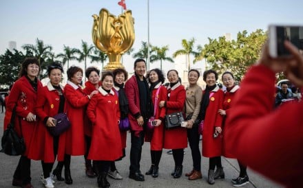 Tourists from mainland China pose for photos in front of the Golden Bauhinia statue, a gift from the central government to Hong Kong in 1997 to celebrate the city’s return to Chinese sovereignty, in Wan Chai in December 2017. Photo: AFP 