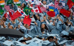 Chinese and other international students wave flags at a Columbia University commencement ceremony last year. Photo: Xinhua