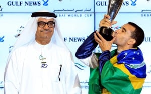 Joao Moreira, draped in the Brazilian flag, kisses the Golden Shaheen trophy after his second win of Dubai World Cup night. Photos: EPA, Kenneth Chan
