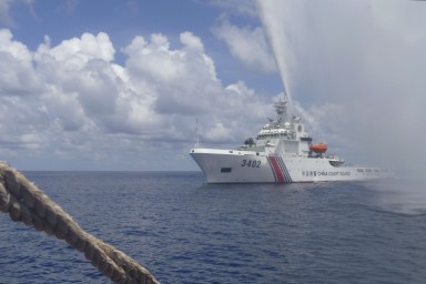 A Chinese coastguard vessel sprays a water cannon at Philippine fishermen near the Scarborough Shoal in the South China Sea in September 2015. Photo: AP