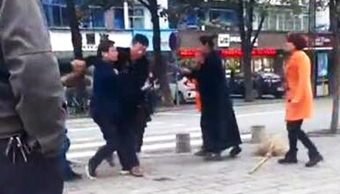 Suit-clad man pummels woman street sweeper on central China roadside
