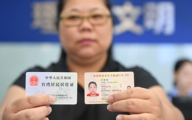 A Taiwanese woman shows off her new mainland residence permit (left). Photo: Xinhua