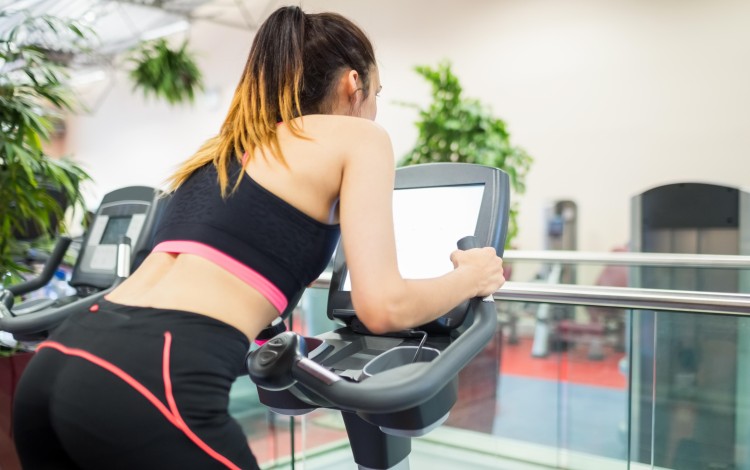 Watching TV while you work out may actually improve your exercise habits. Photo: Alamy