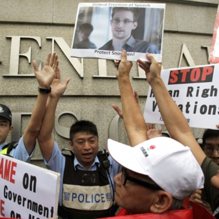 Members of the League of Social Democrats gather at HSBC headquarters in Central before marching to the US consulate general in support of whistle-blower Edward Snowden yesterday. Photo: Edward Wong