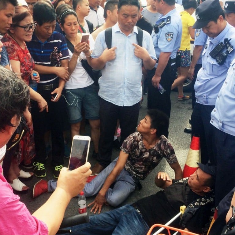 People trying to join a protest against a fraudulent investment scheme in Beijing on Monday lie on the ground after being blocked by police. Photo: Kyodo