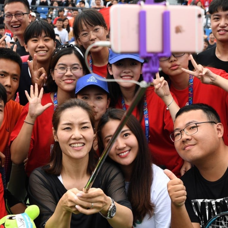 China’s two-time grand slam champion, Li Na, takes selfies with young tennis players during the 2017 WTA Wuhan Open. Photo: Xinhua