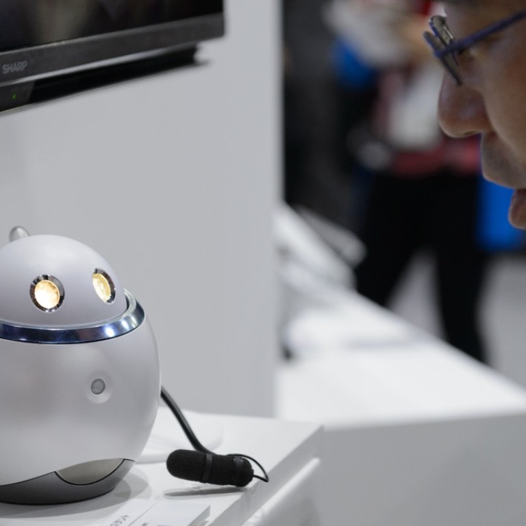 An employee demonstrates Sharp's Home Assistant smart robot prototype at the company's booth at the CEATEC Japan 2017 exhibition in Chiba, Japan. CEATEC is an information technology and electronics trade show. Photo: Bloomberg