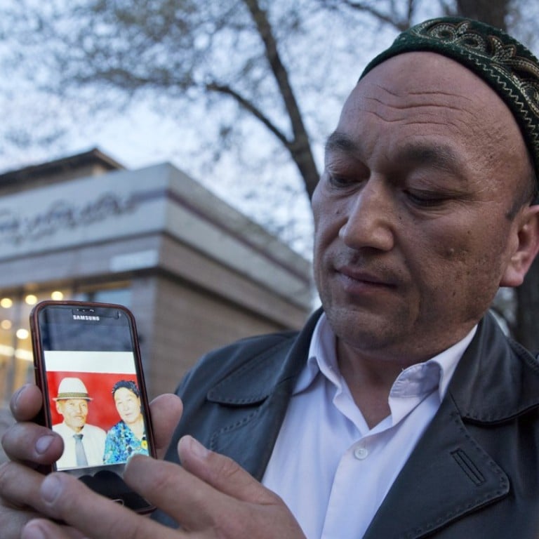 Omir Bekali holds up a mobile phone showing a photo of his parents whom he believes have been detained in China’s western Xinjiang region. Photo: AP