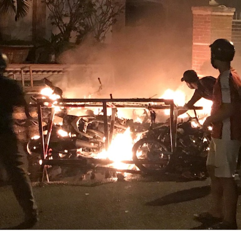 Protesters burning motorcycles in front of a provincial office in Vietnam's south central coast Binh Thuan province. Photo: AFP