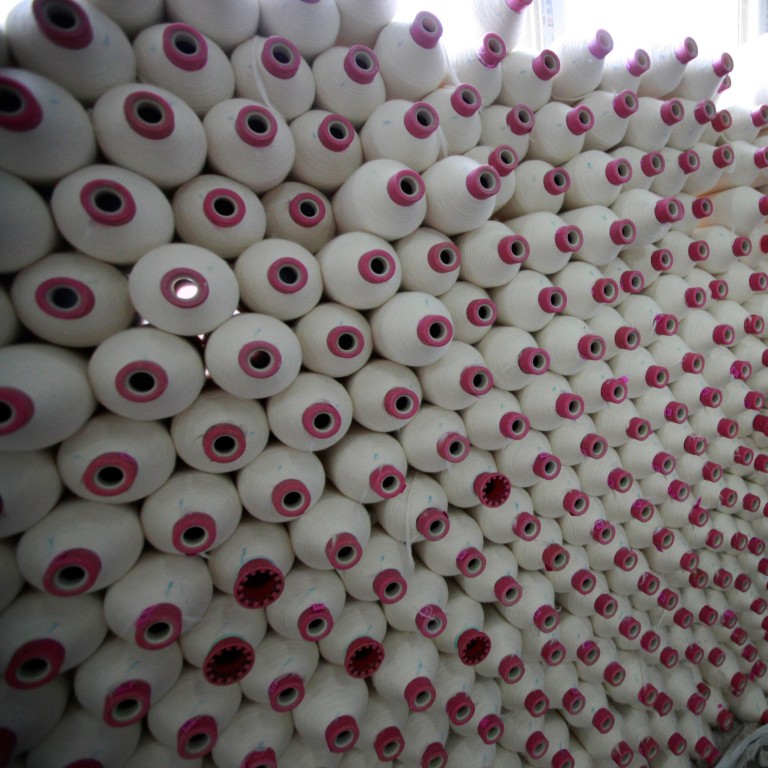 A factory worker with spools of cotton in Huaibei, in eastern China’s Anhui province. Photo: AFP