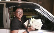 Taxi driver William Wong asks his passengers to sign his guest book. Photo: Xiaomei Chen