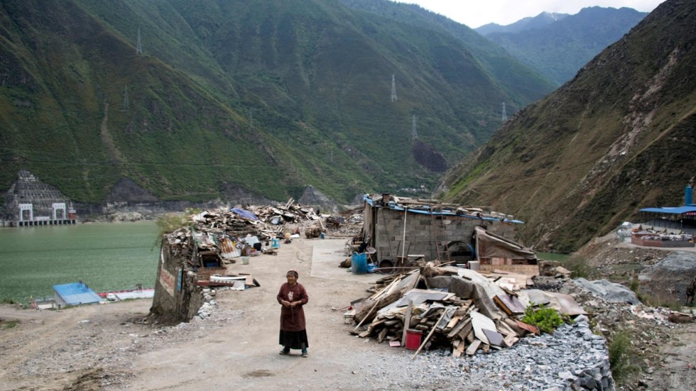 A woman stands next to the debris of demolished houses and her makeshift hut near Lianghekou in Sichuan province, the site of the latest huge dam to be built in China’s drive for greener sources of power. Photo: AFP