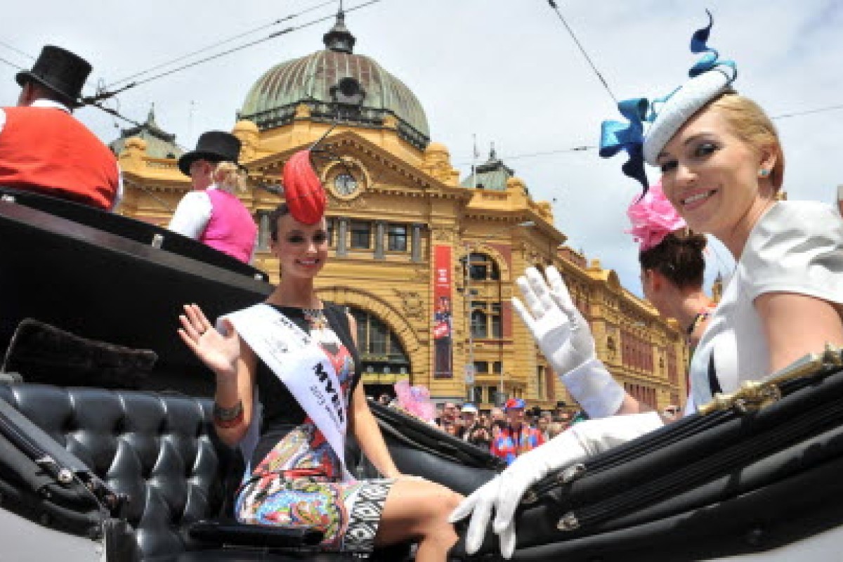 Fashions on the Fields contestants wave during the Melbourne Cup parade in Melbourne on Monday. Photo: EPA