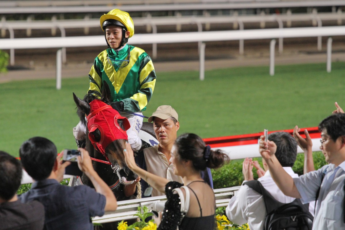 The few punters who flocked to Sha Tin on Wednesday cheer Alex Lai as he returns on Gary Ng's Cheers Victories. Photo: Kenneth Chan