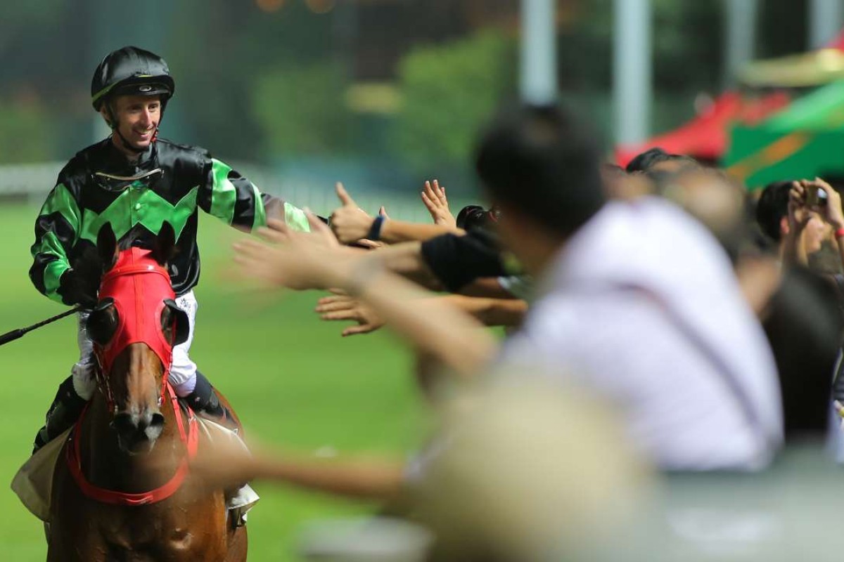 A beaming Nash Rawiller high fives fans after winning the final race of the night on Inventor. Photos: Kenneth Chan