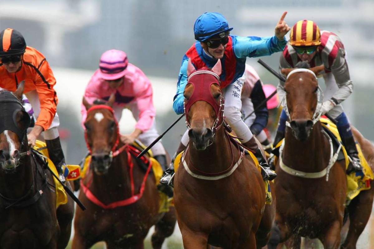 Sam Clipperton (blue and red silks) points to the grandstand after winning the Hong Kong Macau Trophy on Invincible Dragon. Photos: Kenneth Chan