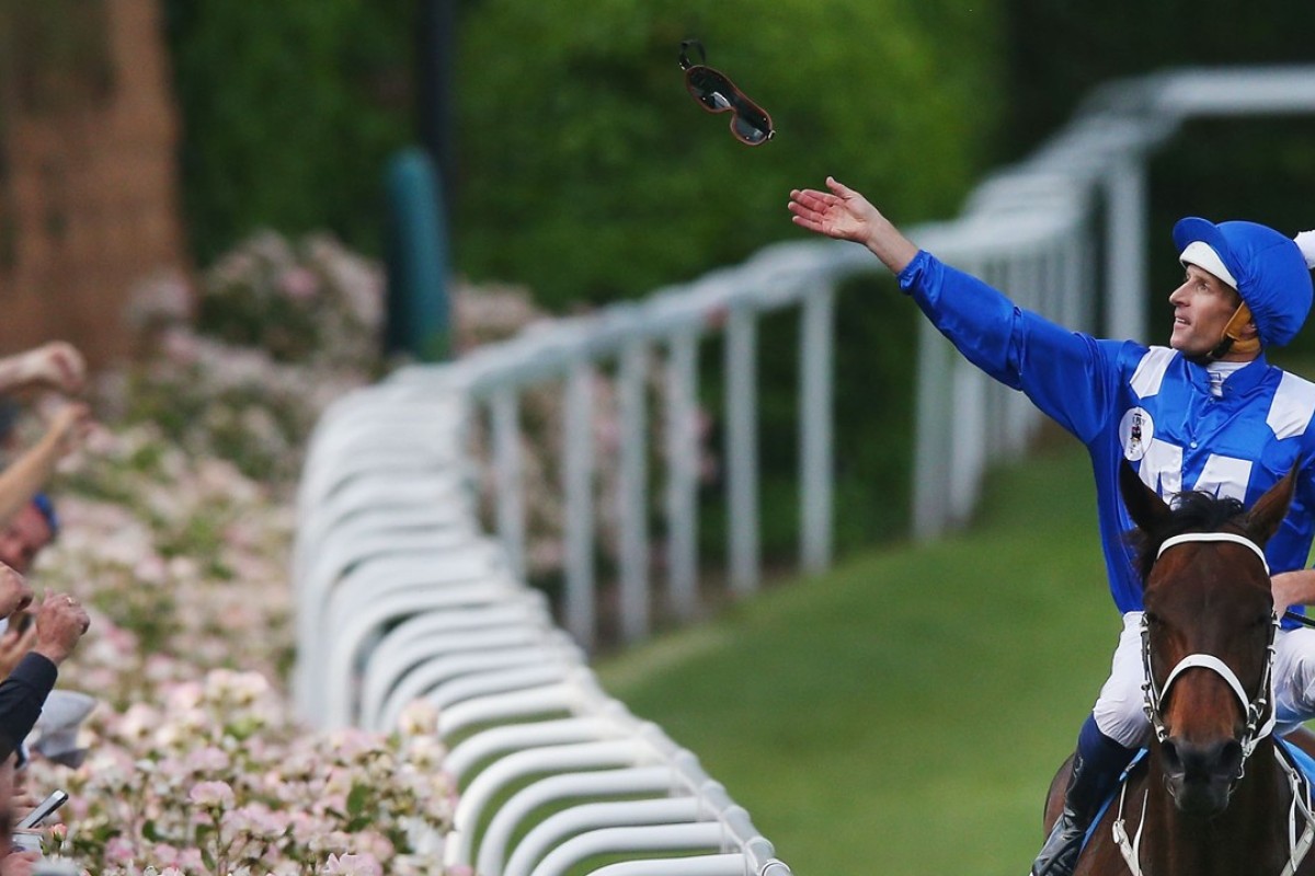 Hugh Bowman throws his goggles to the crowd after Winx’s first Cox Plate victory. Photo: Getty Images