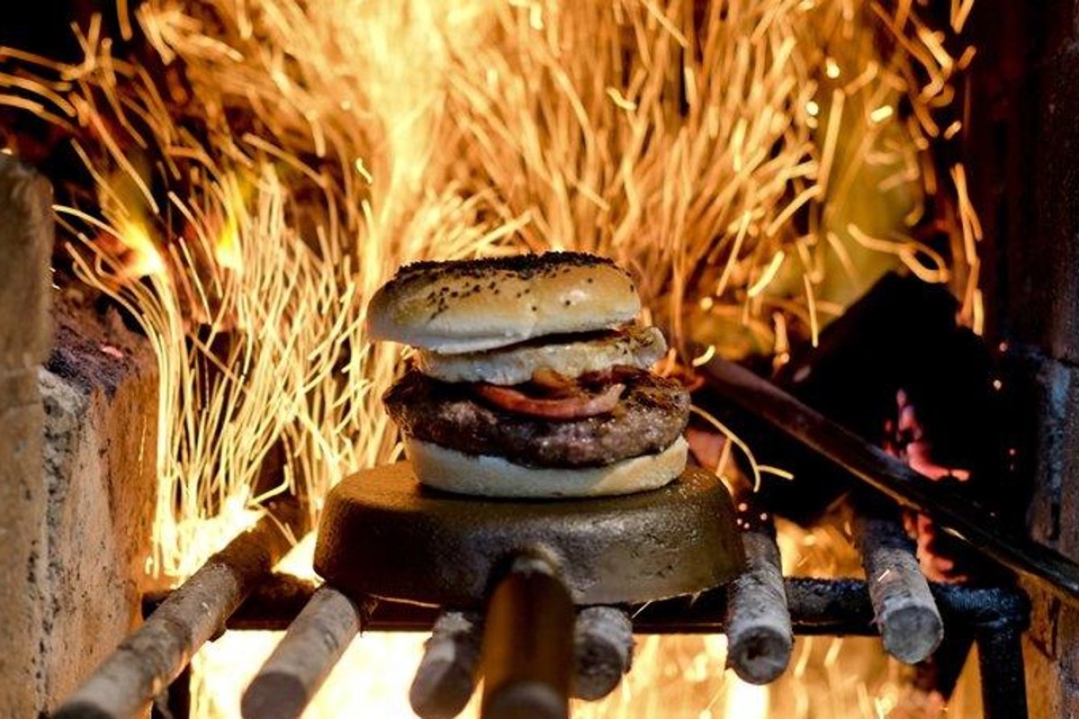 A hamburger is cooked by wood-fuelled fire at Kon Kon restaurant in Buenos Aires, Argentina. Photo: AP
