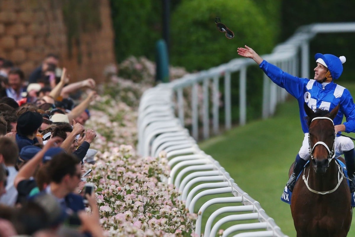 Hugh Bowman throws his goggles into the crowd after winning the Cox Plate with Winx. Photo: Michael Dodge/Getty Images