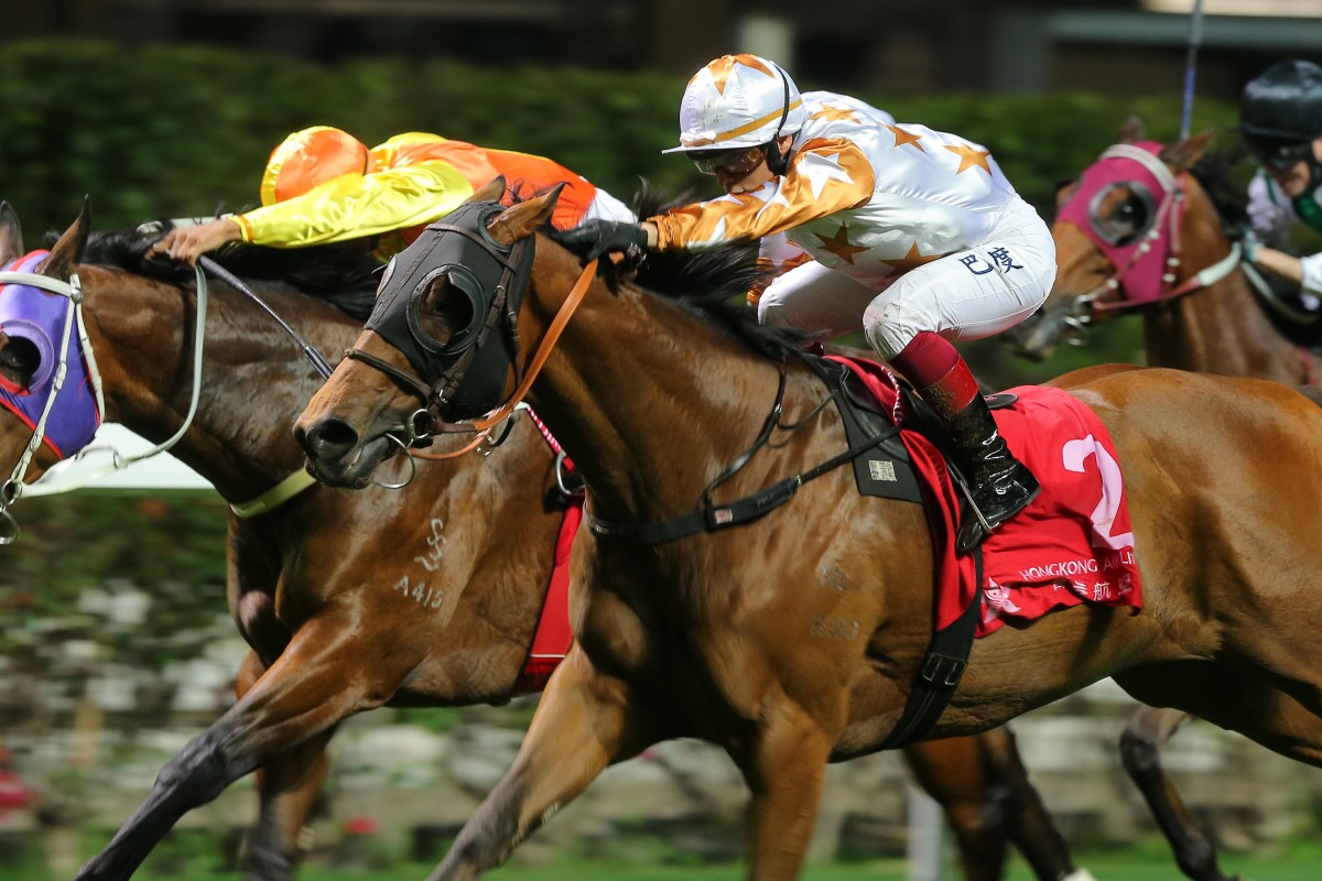Alexis Badel lifts Wishful Thinker to victory in the Class One Happy Valley Trophy on Wednesday night. Photos: Kenneth Chan